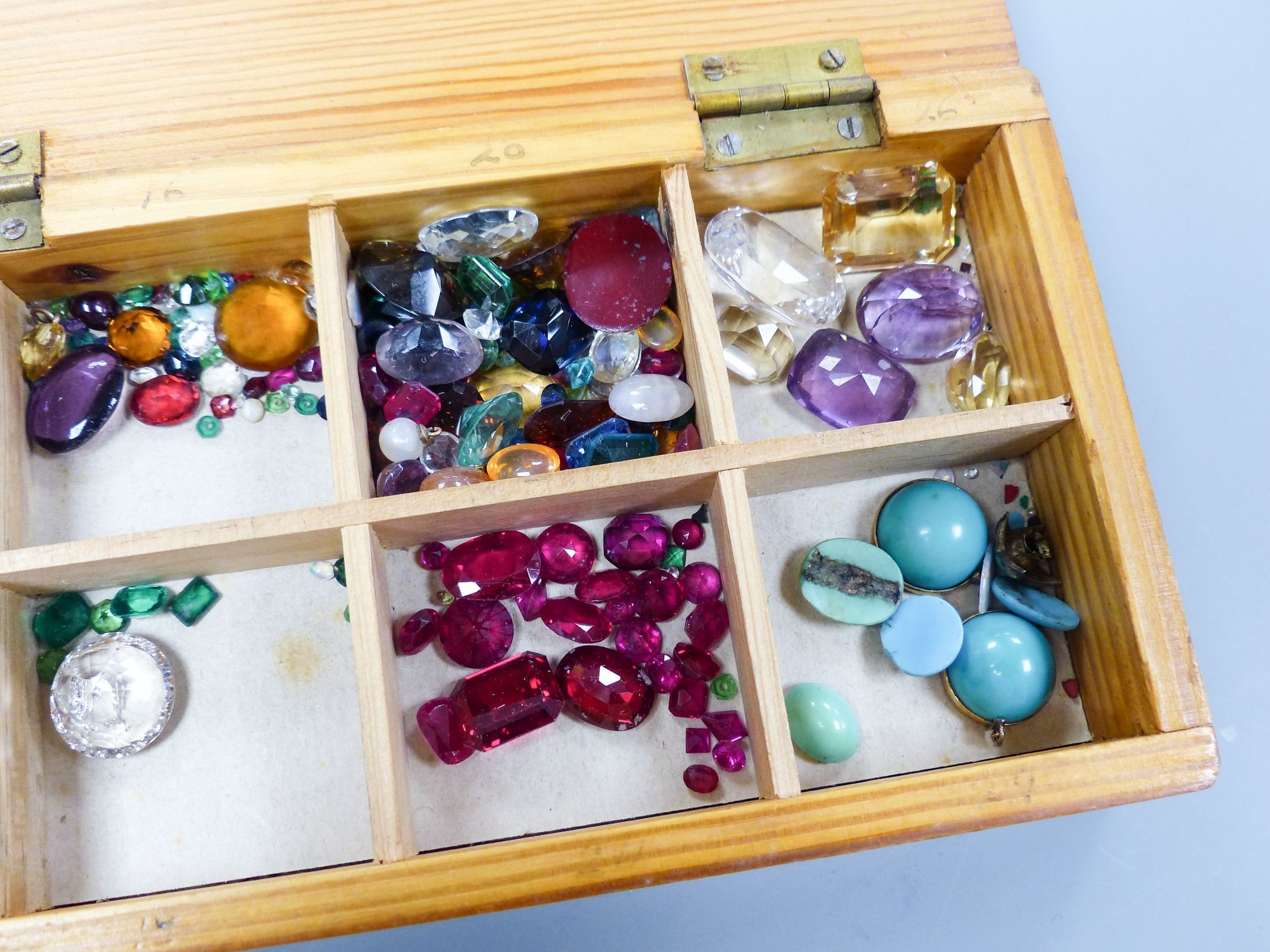 A quantity of unmounted gemstones, housed in a wooden box, including opal, opal doublet, bloodstone, turquoise, amethyst, rock crystal etc.